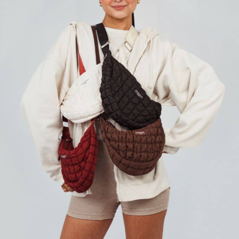Sac demi-lune en bandoulière de Cocopup London en noir, blanc cassé, bordeaux et marron