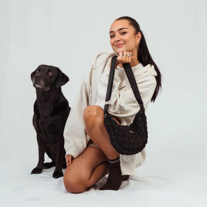 Fille avec un chien et un sac en bandoulière tendance conçu pour promener son chien