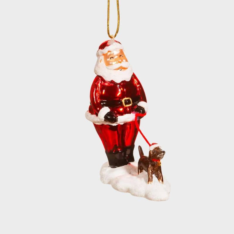 Boule de Noël de la marque Sass and Belle à accrocher dans son sapin d'un père noël promenant un chien