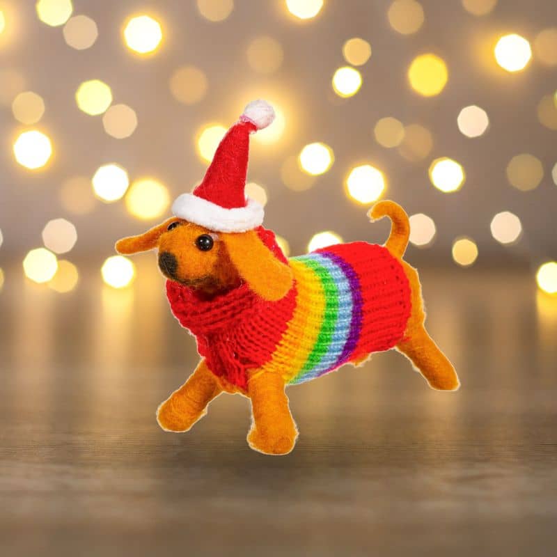 Boule de noël en feutrine qui représente un chien teckel saucisse avec un pull arc-en-ciel de de la marque Sass and Belle