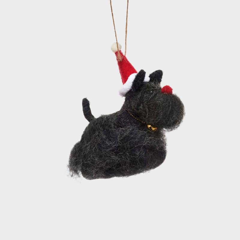 Boule de noël en feutrine qui représente un chien scottish terrier avec bonnet Père-Noël de la marque Sass and Belle à accrocher dans le sapin
