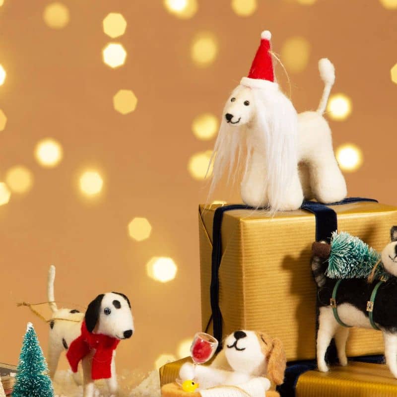 Boule de noël en feutrine qui représente un chien lévrier afghan avec un bonnet rouge Pèr-Noël de la marque Sass and Belle à accrocher dans le sapin