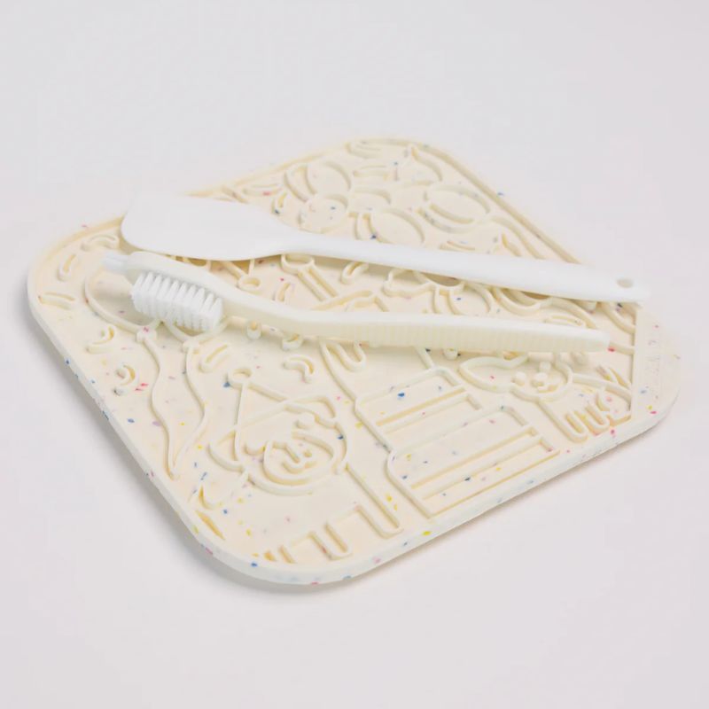 tapis de léchage pour chat et chien beige à motif anniversaire "It's a birthday pawty" par The modern dog company : idéal pour occuper le chien et le calmer