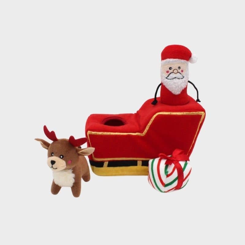Jouet interactif pour occuper son chien en forme de traineau dans lequel cacher des friandises et 3 mini peluches père noel, renne et cadeau 
